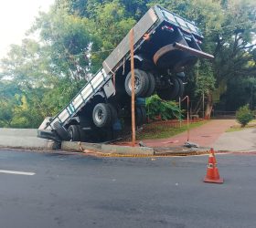 Caminhão carregado com postes cai às margens do Rio Piracicaba e deixa motorista ferido