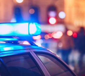 Danger on the street. Blue flasher on the police car at night.